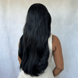 Foto de costas do modelo, Esta peruca tem fios ondulados e compridos com grau de curvatura das ondas entre 2A e 2B, aproximadamente 60 centímetros medidos a partir do topo da cabeça.